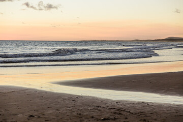 Fototapeta na wymiar Inlet of sea water on the sand, evening light