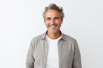 Lifestyle portrait of a Brazilian man in his 50s in a white background wearing a chic cardigan