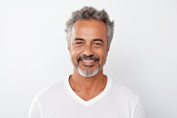 Obraz premium Handsome middle-aged man smiling and looking at camera while standing against white background