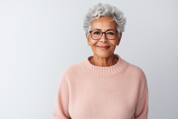 Portrait of a smiling senior woman wearing eyeglasses standing isolated over white background