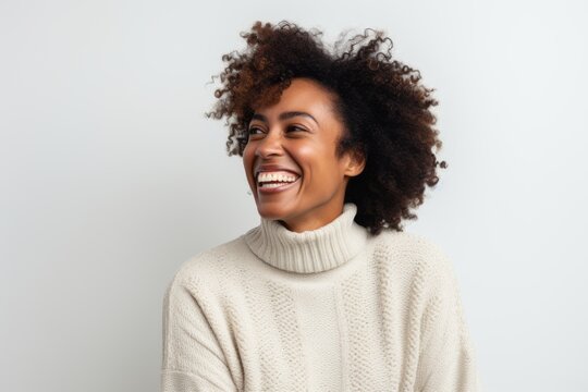 Lifestyle portrait of a Nigerian woman in her 30s in a white background wearing a cozy sweater