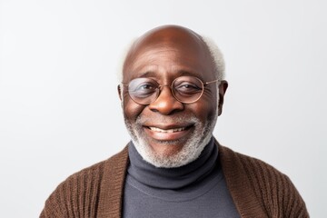 Lifestyle portrait of a Nigerian man in his 60s in a white background wearing a chic cardigan