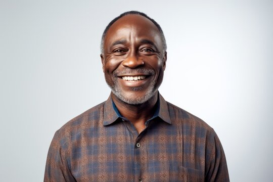 Lifestyle portrait of a Nigerian man in his 50s in a white background wearing a chic cardigan