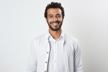 Portrait of a smiling young man in white shirt standing over white background