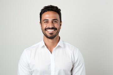 Lifestyle portrait of a Saudi Arabian man in his 30s in a white background wearing a chic cardigan