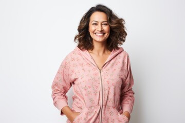 Fototapeta premium Portrait of a happy young woman in pajamas standing over white background
