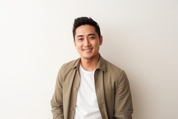 Portrait of a handsome young asian man smiling against white background