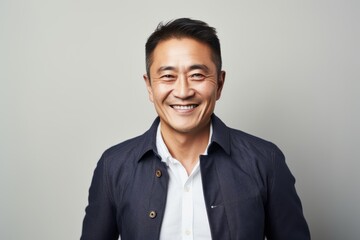Smiling asian man looking at camera isolated on grey background.