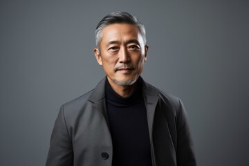 Obraz premium Portrait of a mature asian man in grey suit looking at camera