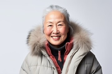 Portrait of a senior asian woman wearing a fur coat and smiling