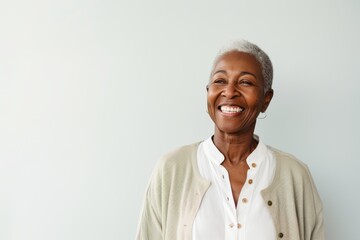 Obraz premium Portrait of a smiling senior woman standing against white background and looking away