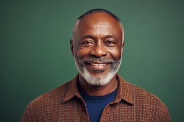 Fototapeta premium Portrait of smiling african american man looking at camera isolated on green background