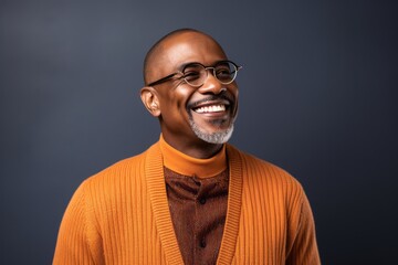 Obraz premium smiling african american man in orange sweater and eyeglasses