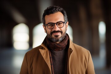 Obraz premium indian male in beige coat and eyeglasses looking at camera