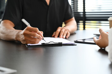 Close up image of businessman hand signing on new contract starting projects in the conference...