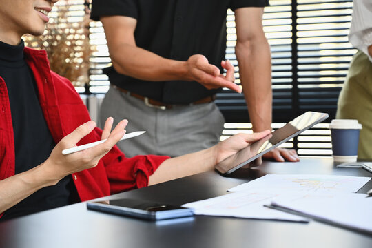 Close up image of creative business people working with colleagues, Senior businessman reviewing or giving advice to subordinates.
