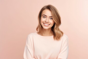 Portrait of a beautiful young woman smiling at camera isolated over pink background