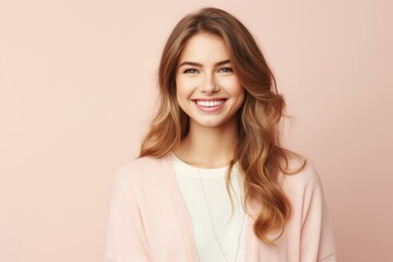 Obraz premium Portrait of a happy young woman smiling at camera over pink background
