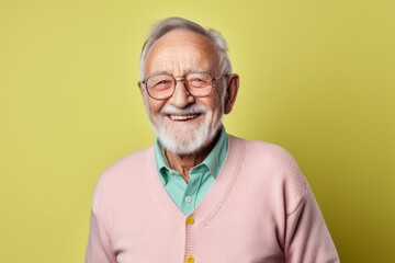 Obraz premium Portrait of a happy senior man with glasses on a yellow background