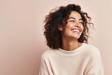Portrait of a beautiful young woman with curly hair smiling and looking up