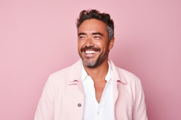 Obraz premium Portrait of a happy young man looking at camera and smiling against pink background