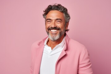 Obraz premium Portrait of a happy mature man smiling and looking at camera isolated over pink background