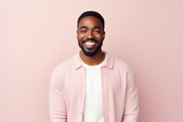 Obraz premium Medium shot portrait of a Nigerian man in his 30s in a pastel or soft colors background wearing a chic cardigan