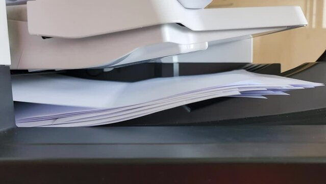 Pile of A4 paperwork documents are print out from photocopy machine in fast motion. 4K footage.