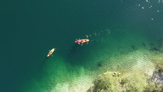 Lake Bohinj with European Alps in the background. Slovenia. Aerial. Summer. Tourists swim in kayaks.