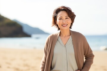 Group portrait of a Chinese woman in her 40s in a beach background wearing a chic cardigan
