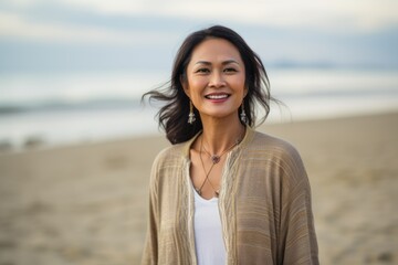 Group portrait of a Indonesian woman in her 40s in a beach background wearing a chic cardigan