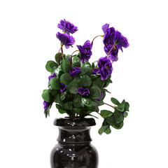 Artificial flowers in a black vase. Close up. On a white background