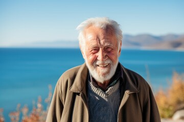 Fototapeta na wymiar Medium shot portrait of a 100-year-old elderly Russian man in a beach background wearing a chic cardigan