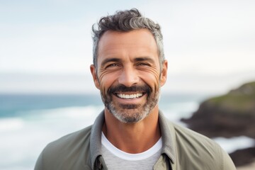Close-up portrait of a Brazilian man in his 40s in a beach background wearing a chic cardigan