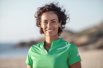 Portrait of smiling female athlete standing on beach at the day time