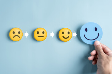 Hand holding blue happy smile face for medical care concept. mental health positive thinking....