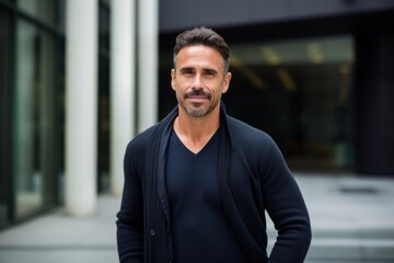 Naklejka premium Portrait of handsome man with hands on hip looking at camera in city