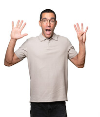 Fototapeta premium Happy young man doing a number nine gesture with his hands