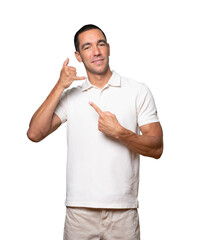 Hesitant young man making a gesture of calling with the hand
