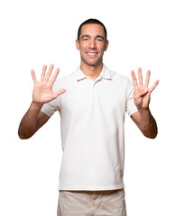 Happy young man doing a number nine gesture with his hands