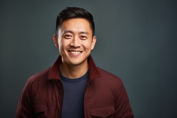 Obraz premium Portrait of a happy young asian man isolated on gray background