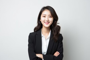 Portrait of a Chinese woman in her 20s in a white background wearing a classic blazer