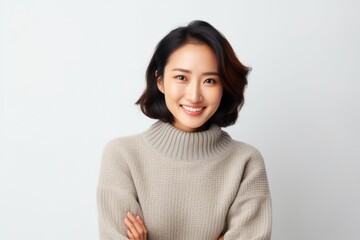 Fototapeta premium Portrait of a Chinese woman in her 30s in a white background wearing a cozy sweater