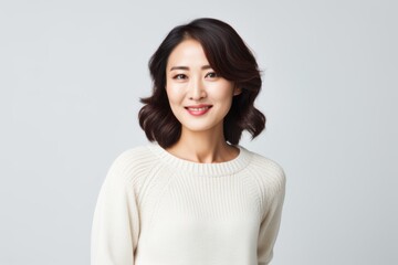 Obraz premium Portrait of a Chinese woman in her 30s in a white background wearing a cozy sweater