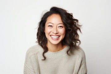 Fototapeta premium Portrait of a Chinese woman in her 30s in a white background wearing a cozy sweater