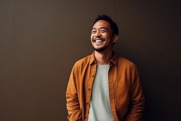 Obraz premium Portrait of a happy young asian man smiling against grey background