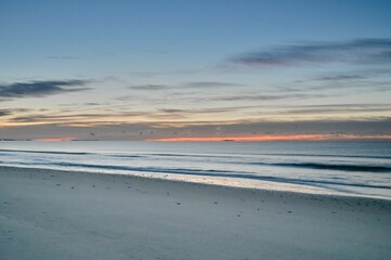 Aerial view of sea waves breaking beach during sunset