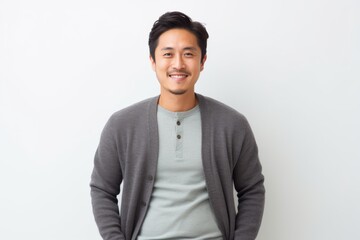 Portrait of a Chinese man in his 30s in a white background wearing a chic cardigan