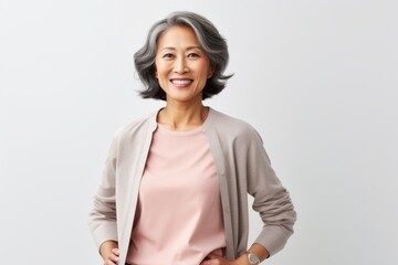 Portrait of a happy mature asian businesswoman standing against white background