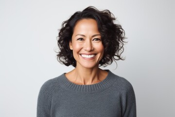 Portrait of a Chinese woman in her 40s in a white background wearing a cozy sweater